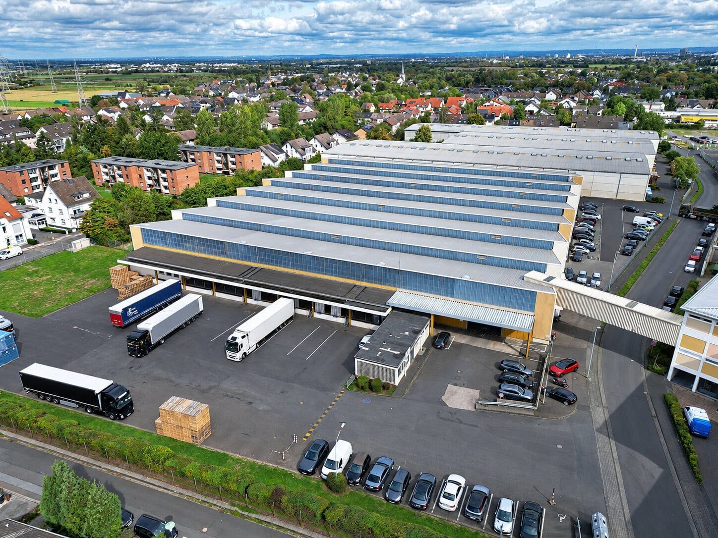 Aerial view of the WECK distribution centre on Maarbachstraße / Alter Heerweg in Alfter near Bonn, showing the sawtooth-roof warehouses, loading area and parking spaces